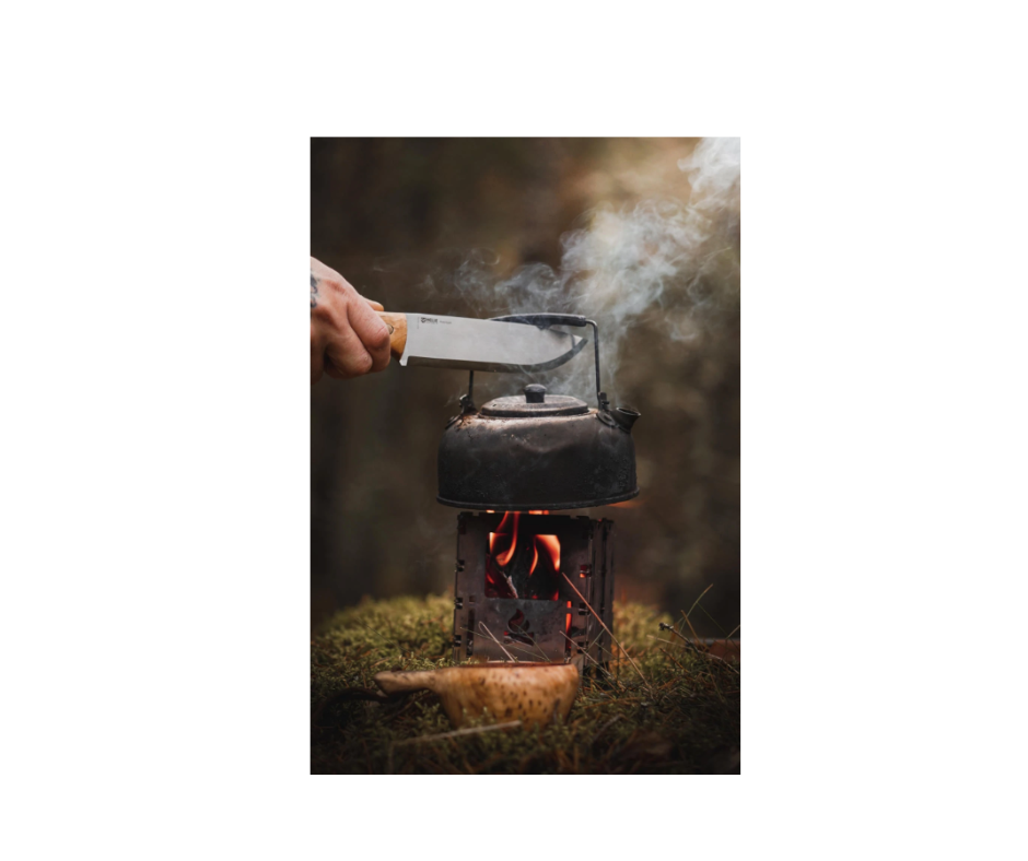 Helle Nord kniv brugt ved bål til kedel i naturen med røg og flammer